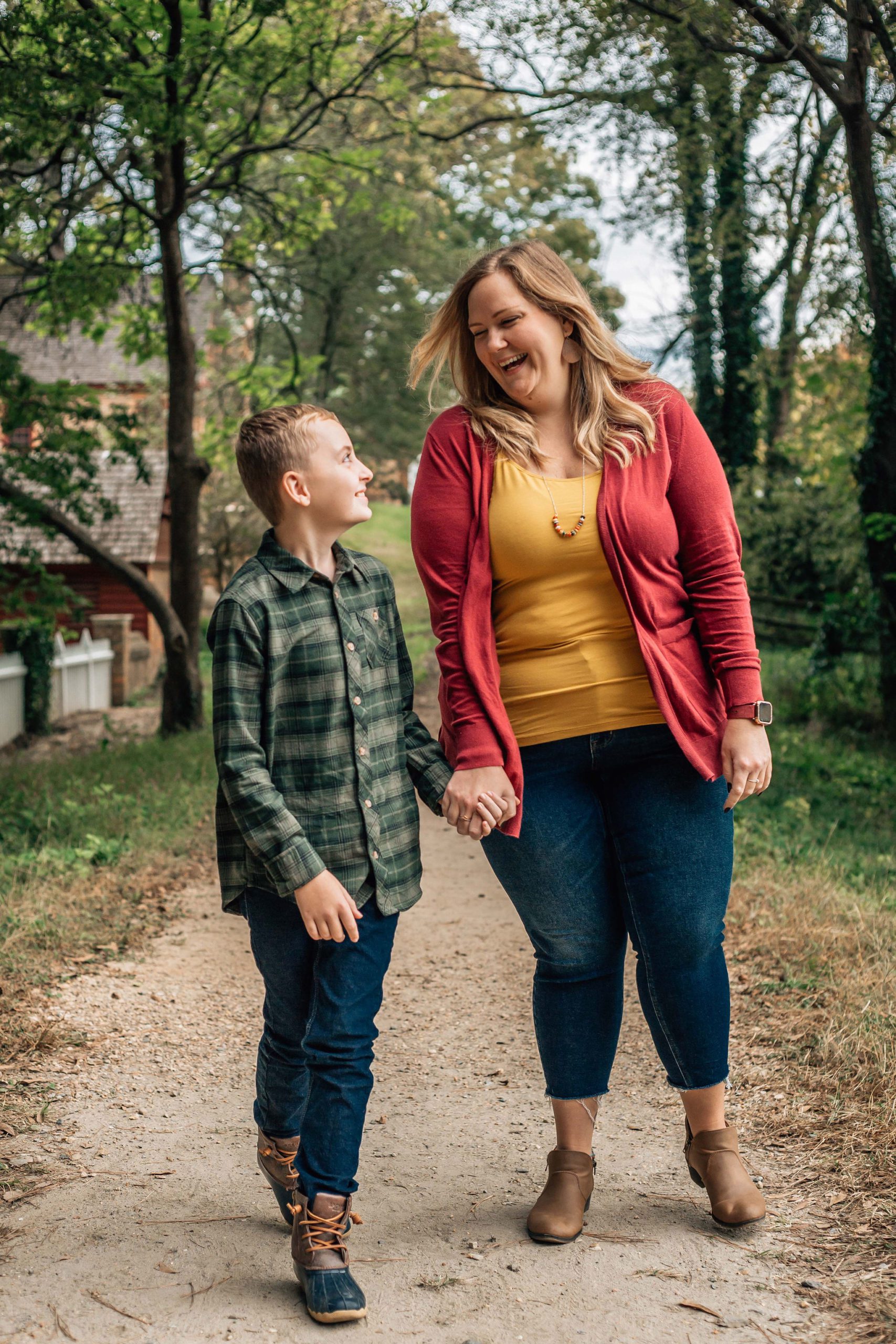 mom and son holding hands and walking to the camera for their Hampton Roads family photos 