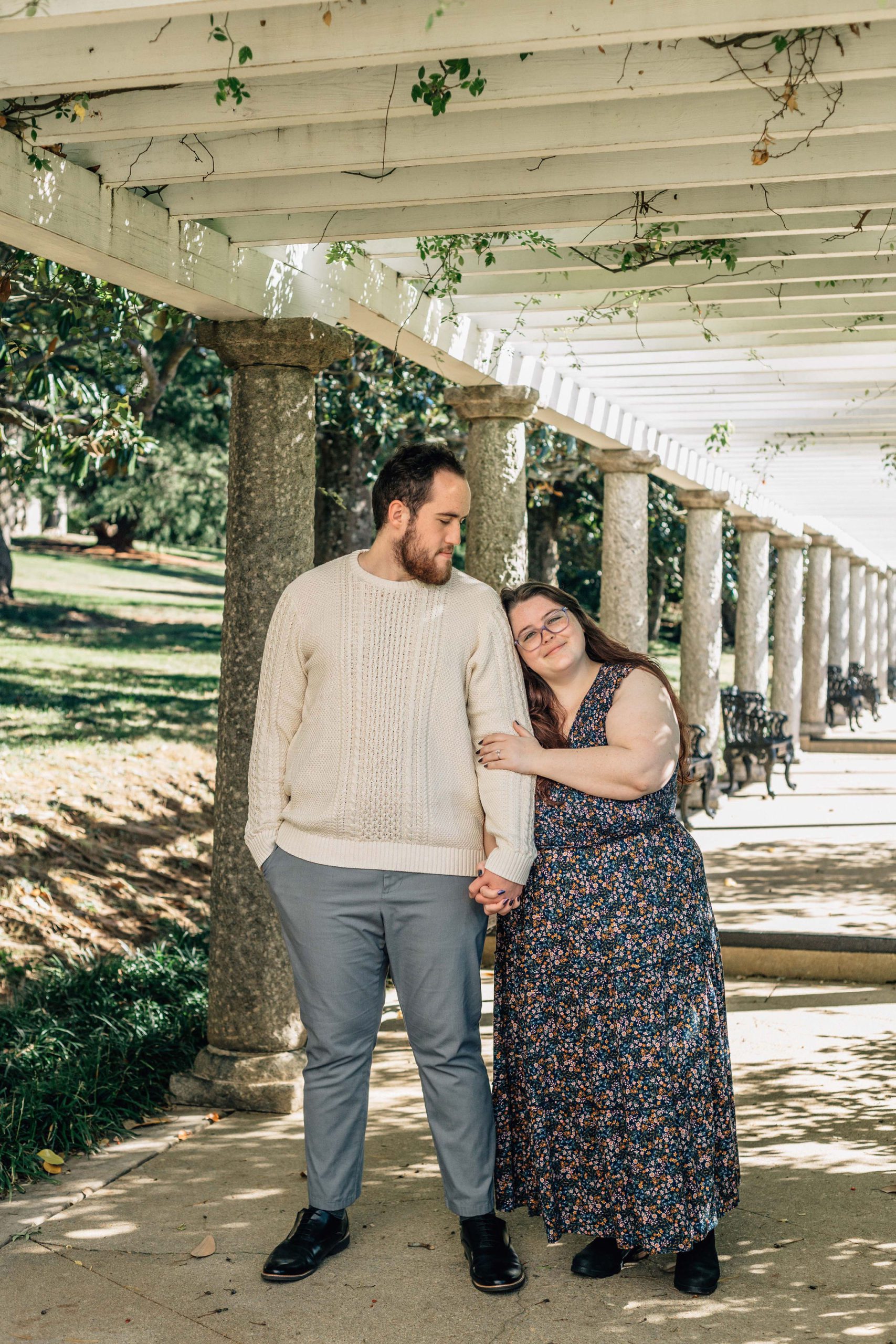 Hampton Roads engagement photographer natural engagement photo pose idea captures engaged couple holding hands and leaning into each other in a garden