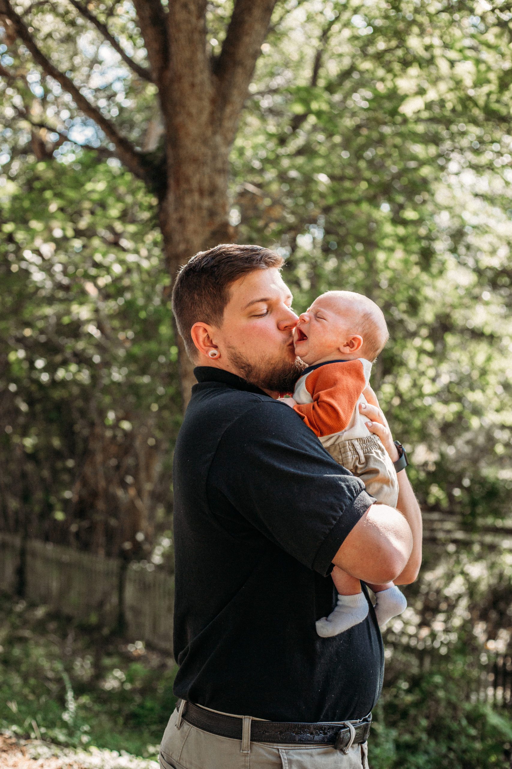 first time dad holding his son and kissing his cheek captured by best Hampton Roads family photographer