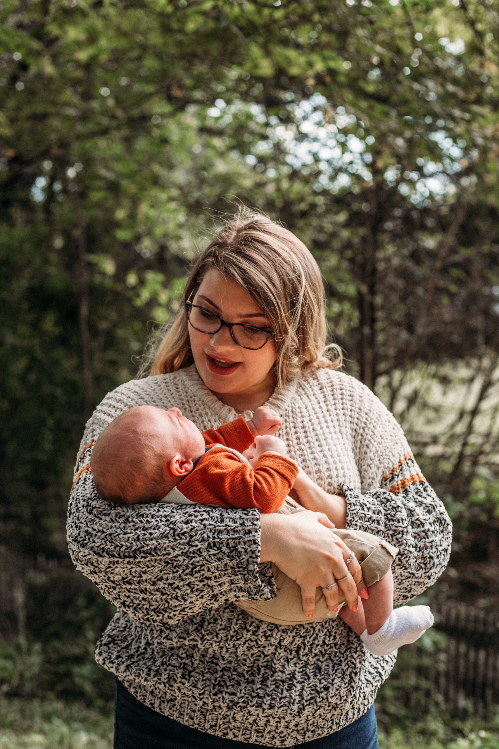newborn baby boy being held by his aunt as she rocks him during their family photo session
