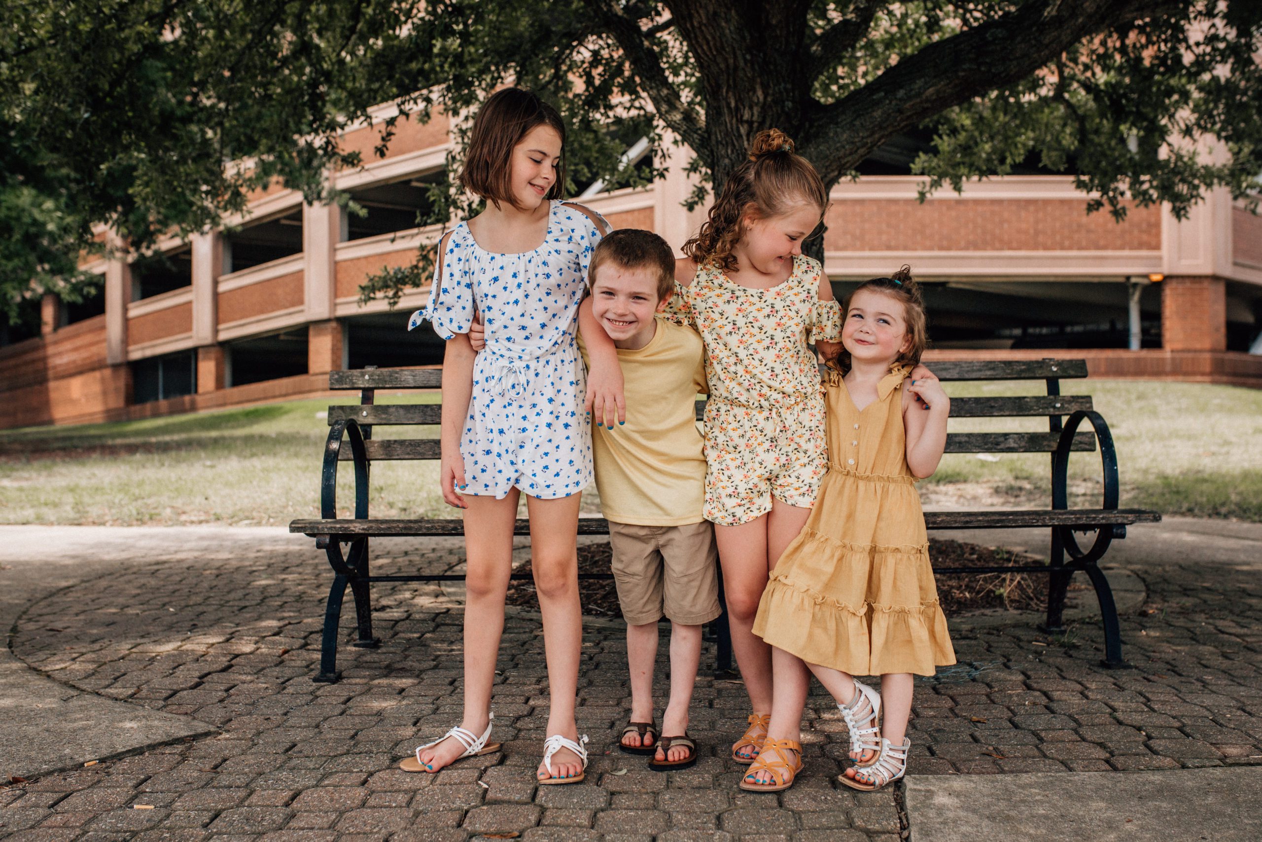 Hampton Roads family photos with four siblings hugging each other around the shoulders