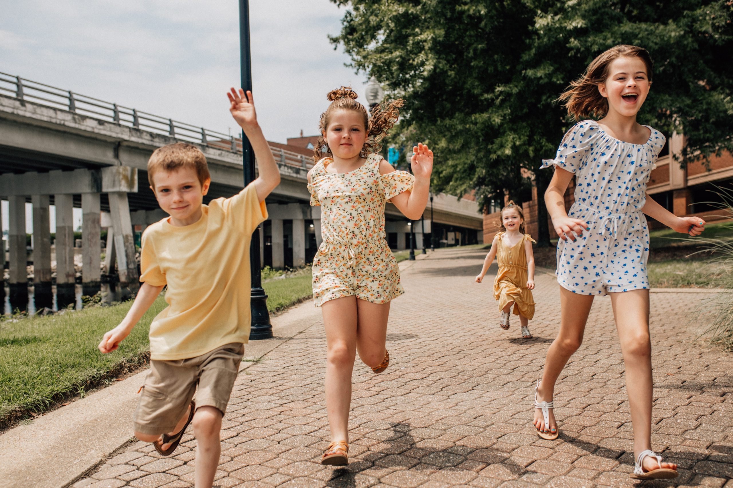 little children running towards the Hampton Roads family photographers camera on a sunny summer day 