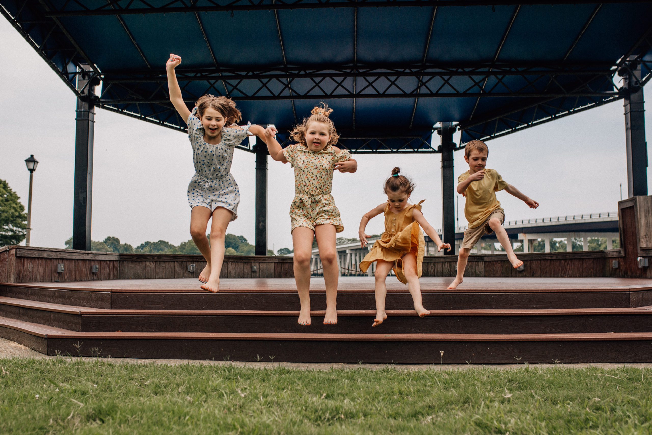 four little children jumping from a set of stairs in the Hampton Roads for their family photos